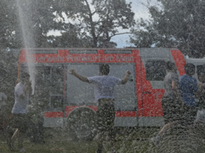 Die Feuerwehr kühlt die Schülerinnen und Schüler während des Spendenlaufs mit kühlem Wasser. 