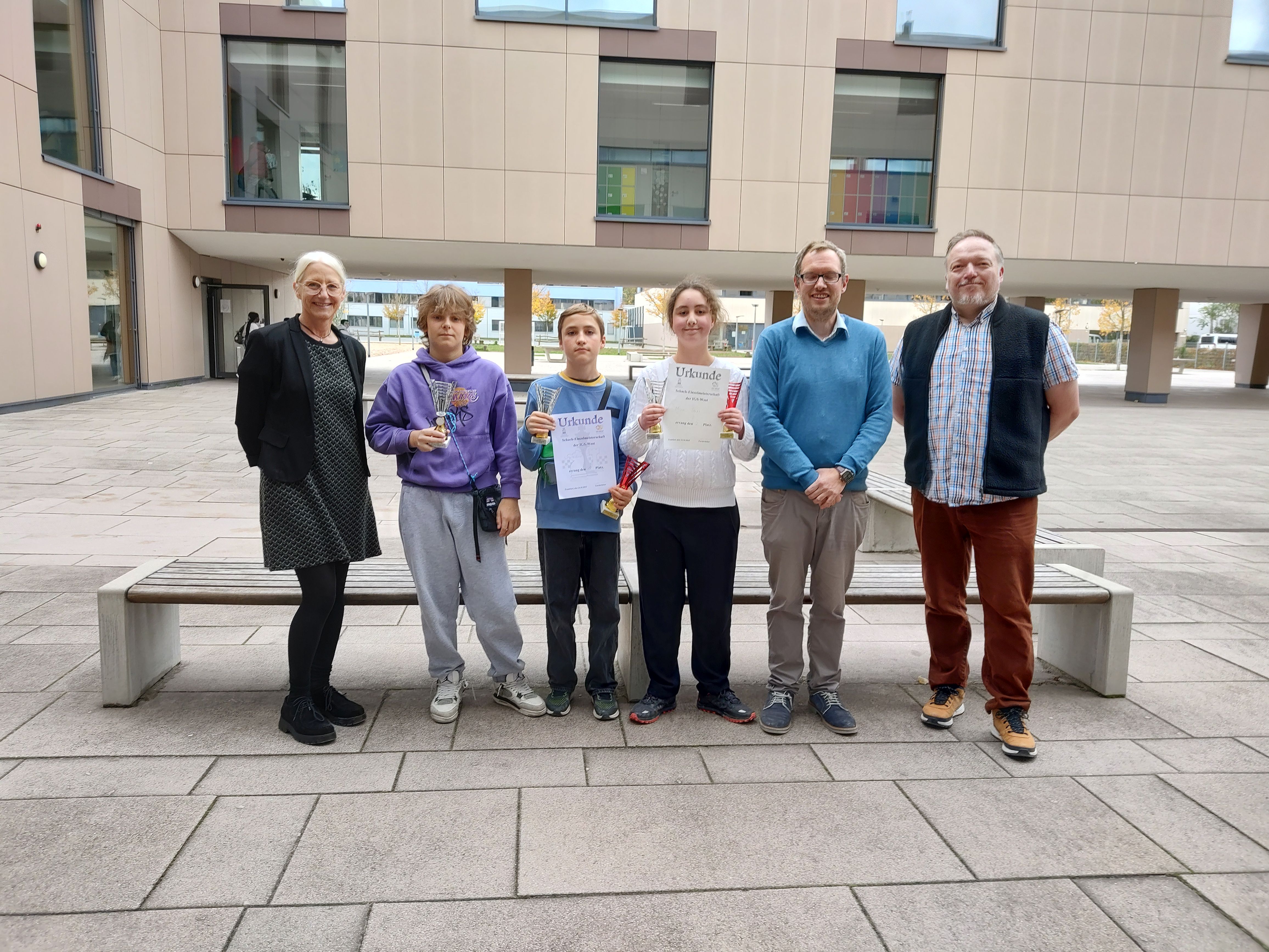 Siegerehrung des neuen Schachmeisters auf dem Schulhof mit Schulleitung, Schach AG-Leiter 